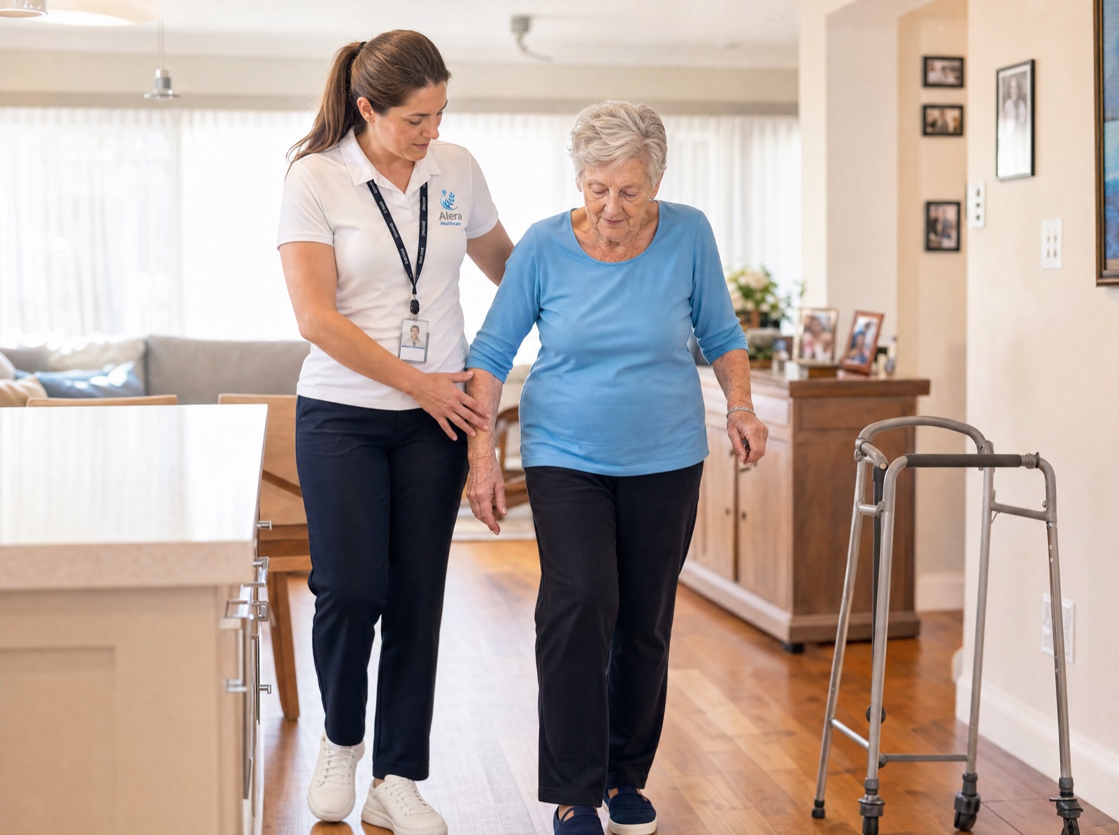 An Alera Healthcare physiotherapist supporting an elderly woman through a balance and walking exercise in her own home.